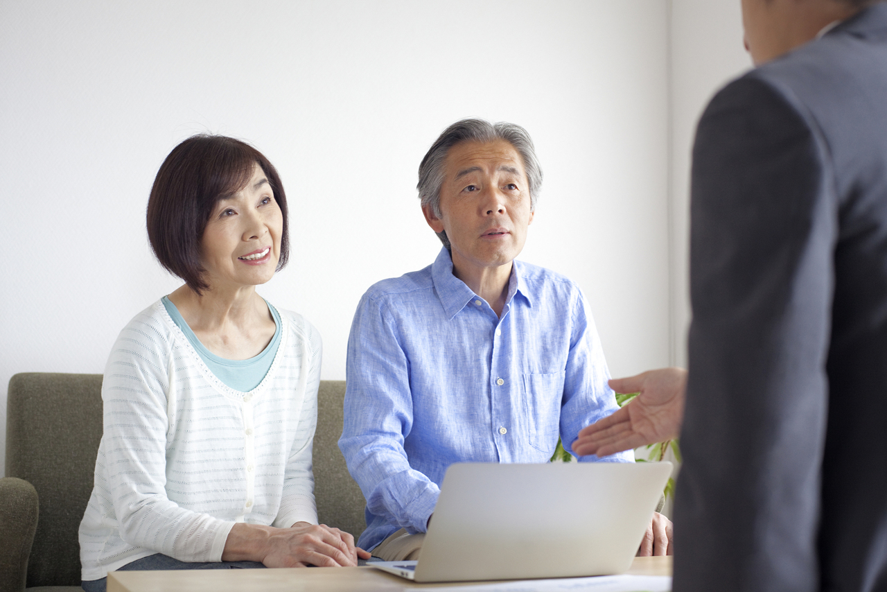 相談相手の説明を聞くシニア夫婦のイメージ